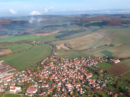 Blick auf Kaltensundheim und die Hügel der Thüringer Vorderrhön im Oktober. Auf dem Bild ist die hügelige Landschaft und die Nähe zum Projektgebiet des Naturschutzgroßprojektes gut zu erkennen (Foto: D. Stremke 2008)
